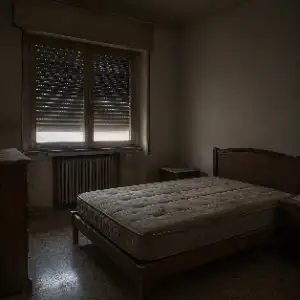 Camera da letto vuota e disabitata con materasso spoglio